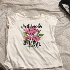 White t-shirt with pink flowers.